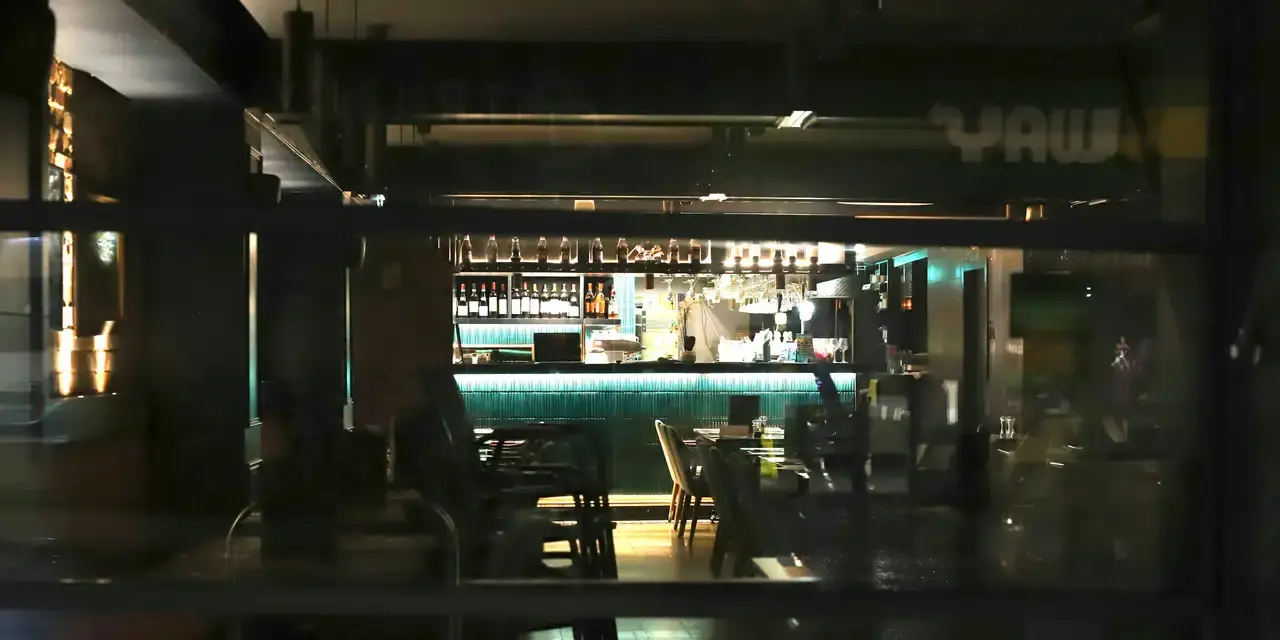 Barra iluminada de un local vista desde la calle de noche