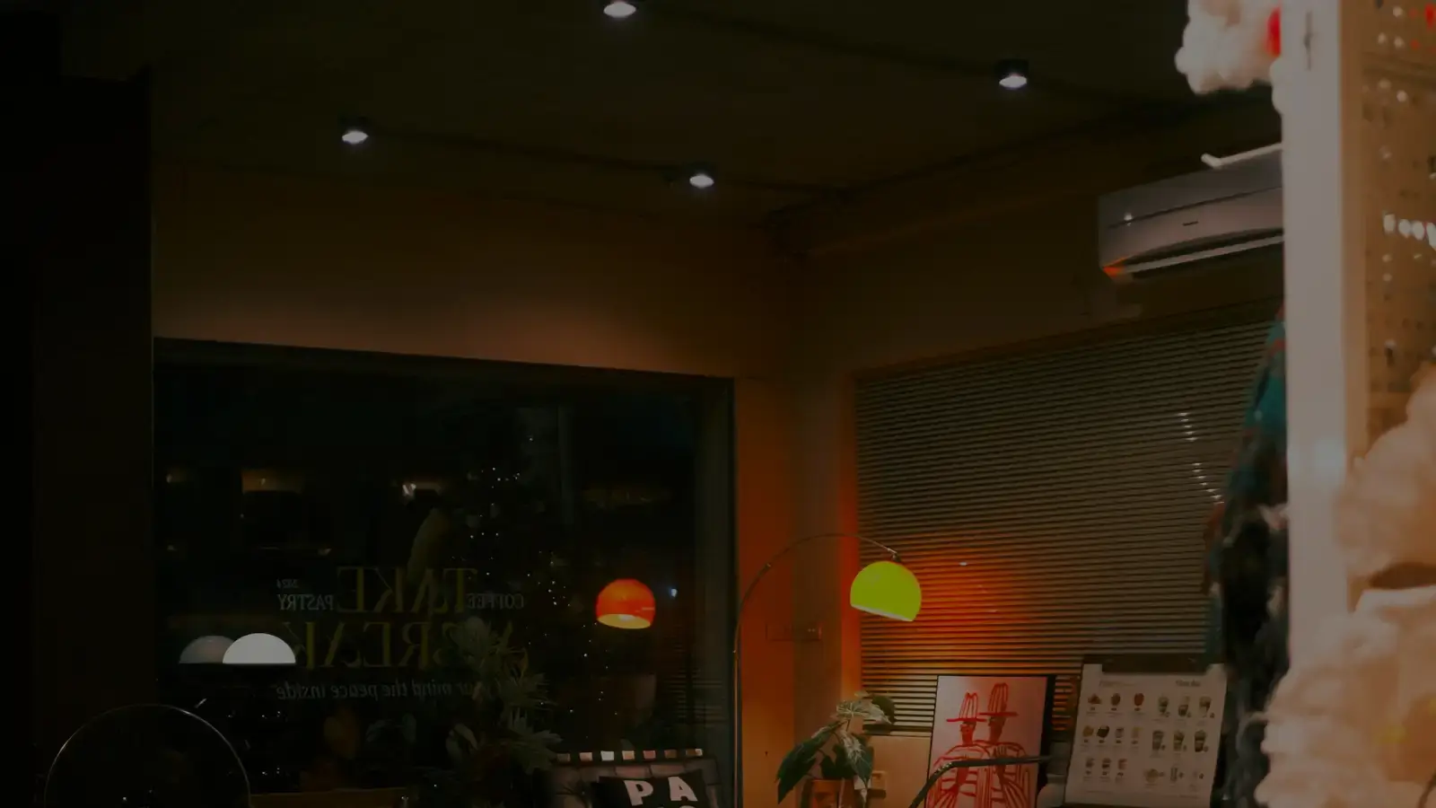 Escaparate iluminado de un pequeño comercio de barrio al anochecer