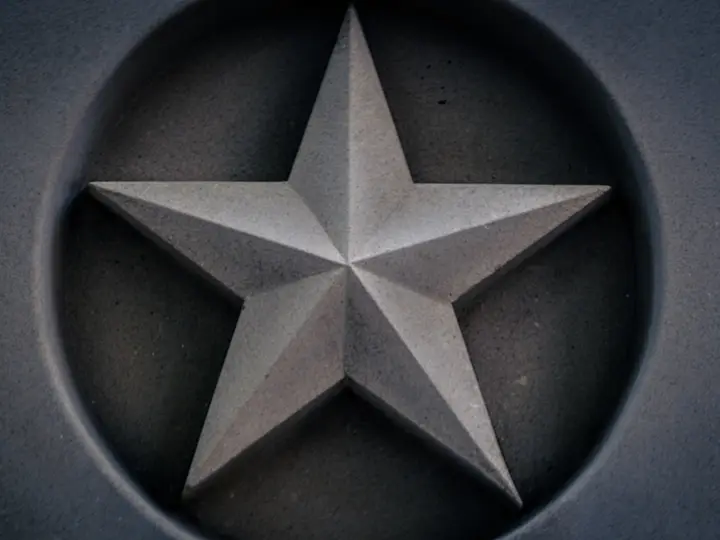 Estrella de cinco puntas tallada en un panel de hormigón oscuro